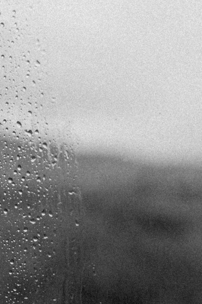 Black and white photo of rain droplets on a windowpane